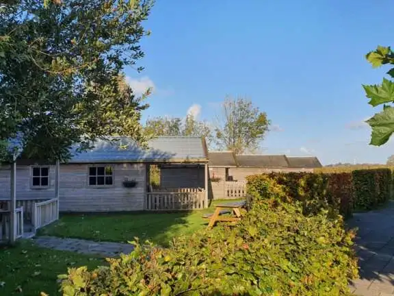 Knusse trekkershut in de herfst in Friesland aan het water